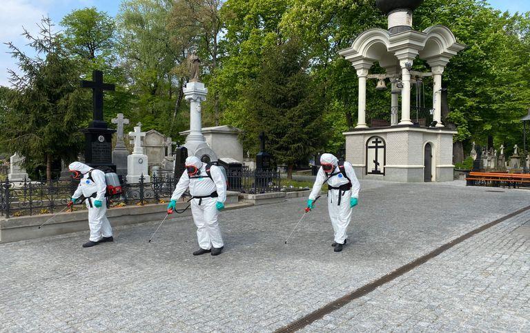 Mężczyźni dezynfekujący chodnik